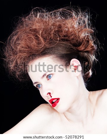 Portrait of a pale woman wearing red lipstick and a bloody nose isolated against a black background.