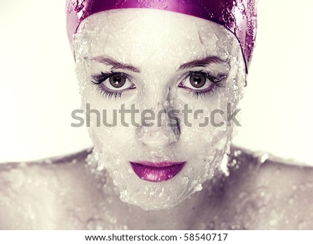 splashes and drops of water on  young female face wearing swimming hat