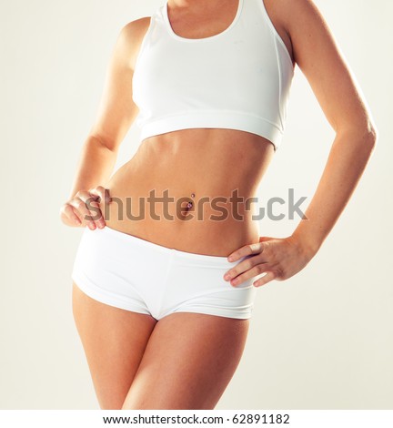 Slim tanned woman\'s body. Isolated over white background.