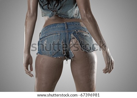 Sexy woman standing from the back wearing wet ripped tiny booty shorts
