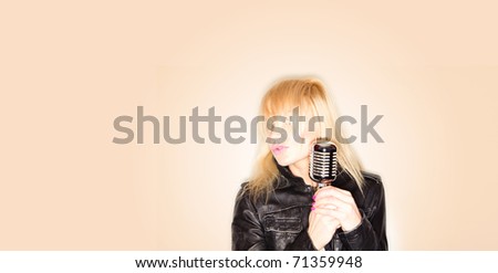 blonde woman holding a retro microphone wearing black jacket , singing rockstar