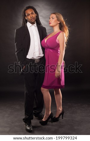 young multiracial couple with a dreadlock African American man wearing suit and cute blond woman dancing wearing dress