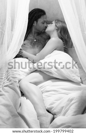 Young passionate couple making romantic love in bed