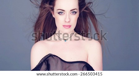 Close up Portrait of a Seductive Young Woman, Wearing Black See Through Tops, Looking at Camera. Isolated on Gray Background.