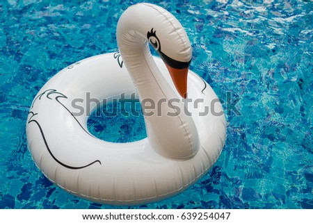 Inflatable white swan float in the outdoor swimming pool