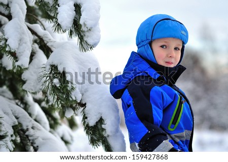 the boy in the forest. Portrait of a child. Winter and cold. Happy kid.