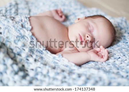 Portrait of sleeping newborn child hidden blanket