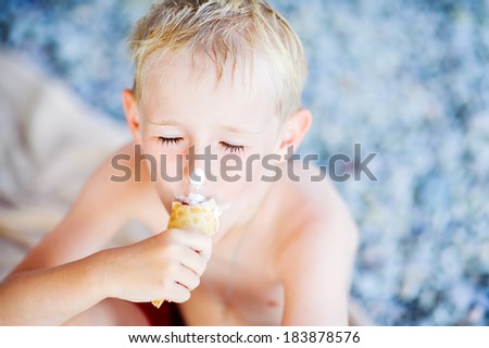 little boy with eyes closed eating ice cream in the summer