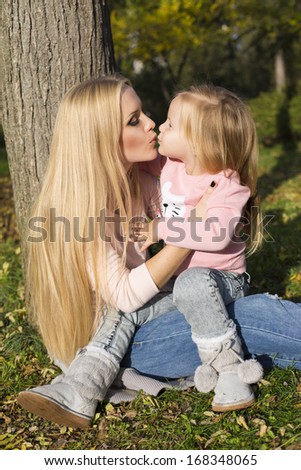 beautiful mother kissing her little daughter