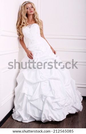 fashion photo of beautiful elegant bride in wedding dress posing at studio