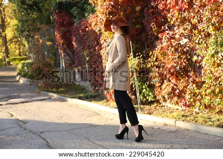 fashion outdoor photo of beautiful elegant woman with dark straight hair wearing elegant coat and hat,posing in autumn park