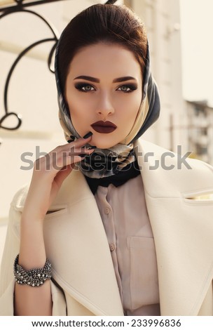 fashion outdoor photo of beautiful elegant lady wearing luxurious beige coat and silk scarf on her head