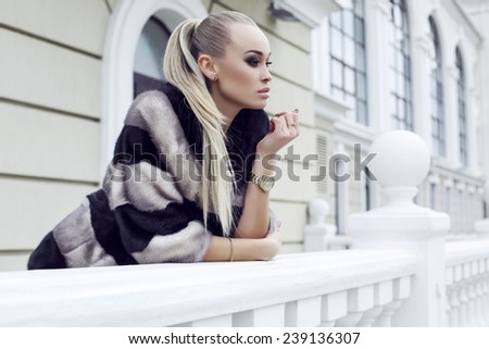 fashion outdoor photo of sexy beautiful woman with long straight hair wearing luxurious fur coat