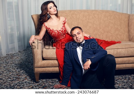 fashion interior photo of beautiful tender couple in elegant clothes posing in bedroom