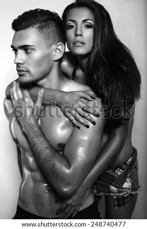 black and white fashion photo of sexy impassioned couple in jeans clothes posing in studio
