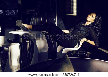 fashion indoor photo of beautiful sensual woman with dark hair in elegant clothes posing in luxury interior