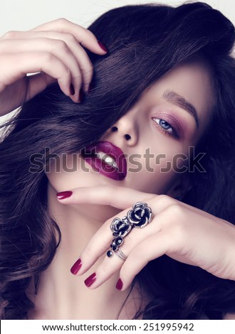 fashion studio portrait of gorgeous woman with dark hair and blue eyes,with manicured nails and bijou