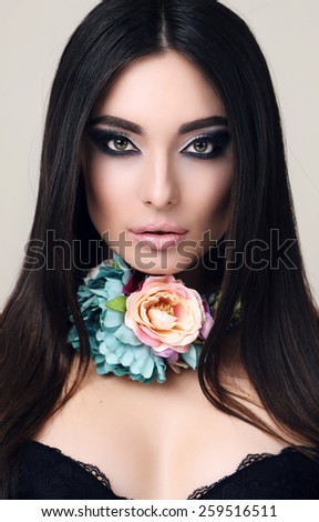 fashion portrait of beautiful sensual woman with straight black hair with bright makeup and flower\'s necklace
