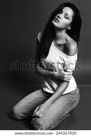 black and white fashion photo of beautiful sensual woman with dark hair and natural makeup, wearing jeans