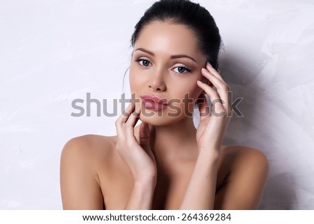 fashion photo of beautiful woman with dark hair with natural makeup and radiance health skin posing in studio