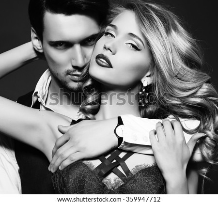 black and white fashion studio photo of beautiful couple, wears elegant clothes, embracing each other