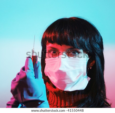 Medicine doctor with medical syringe in hands, A(H1N1), an abstract color environment. Focus is on the syringe
