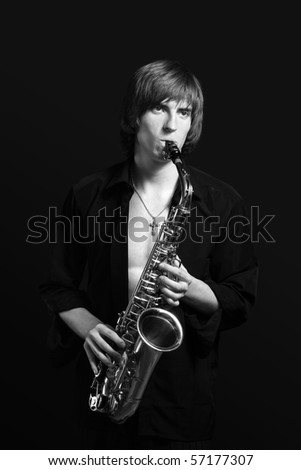 Man with a sax musical instrument on tne black background