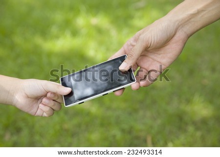 A mother giving her child a mobile phone