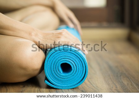 Young woman holding a yoga mat