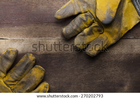 old dirty leather work gloves on wood background
