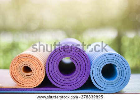 many yoga mats on the wood table in the garden