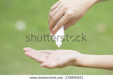Beauty girl applying some white lotion on her perfect hand