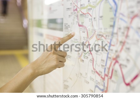 A tourist pointing the tourist attraction on a map public