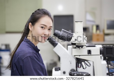 female scientist looking in microscope in laboratory Laboratory Microscope