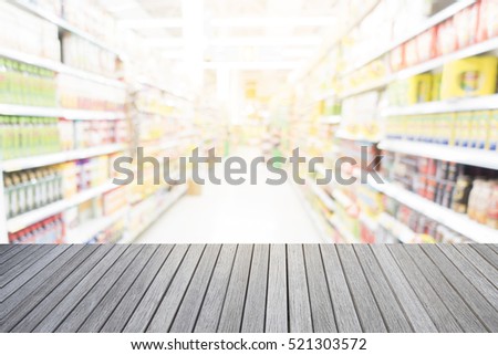 Empty top of wooden table and supermarket blur background