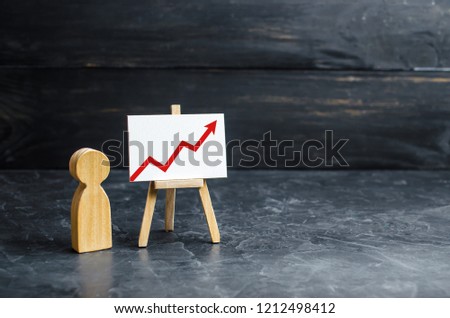 A person is standing near a chart with a red up arrow. Financial success and achievement. Business report and idea. Summarizing. Analysis and market research. Education in economics. Statistical data