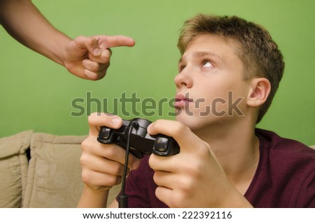 Parent schooling his kid not to play video games. Kid with sad face looking up.