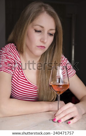 Sad depressed cute girl drinking alone.