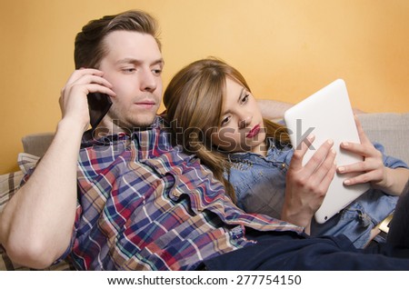 Young couple preoccupied with technology, does not pay attention to each other. Relationship problems, to much work, no free time.