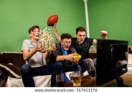 Ecstatic family, father and sons cheering for touchdown, while watching american football, funny