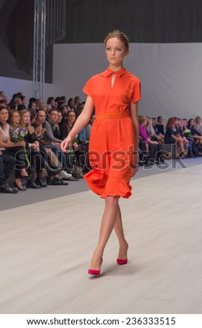 MINSK/BELARUS - NOVEMBER 2014: Unknown model walks the runway in orange dress at Belarus Fashion Week on November 14, 2014 in Minsk, Belarus