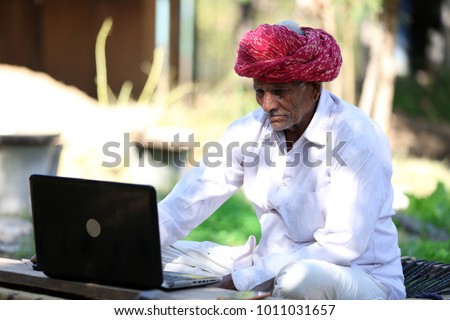 Indian farmer working on Laptop. Modern farmer of India. Tech Savvy Indian Grandpa. Indian Grandpa loves playing with laptop. Technology reaches rural India.Which laptop to buy for Seniors.