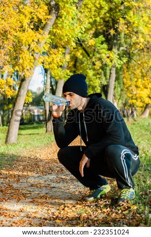 Man is refreshing himself with water after workout/ Man is refreshing himself with water after workout