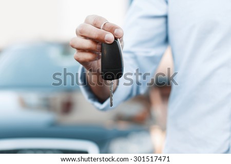 Businessman holding a car key.