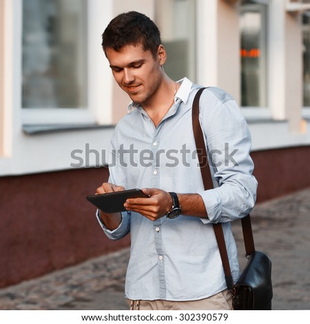 Happy young male executive using digital tablet.