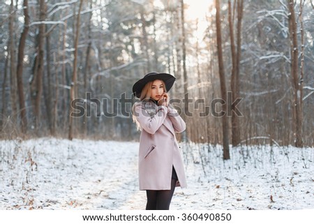 Young beautiful girl in fashionable clothes on a sunny winter day