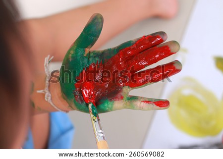 Little boy showing hands painted in colors