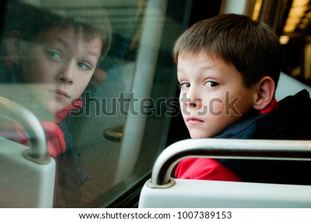 Young Boy\'s Reflection in Window of Metro