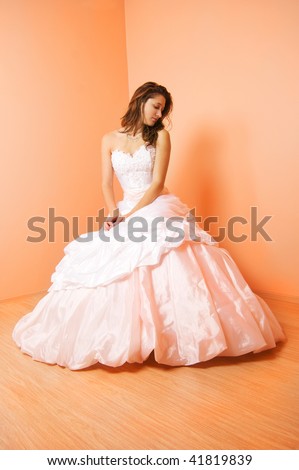 stock photo Beautiful bride in a wedding dress sitting on the chair in the 