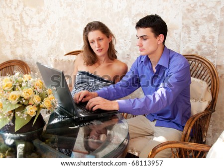 Young couple searching something with laptop
